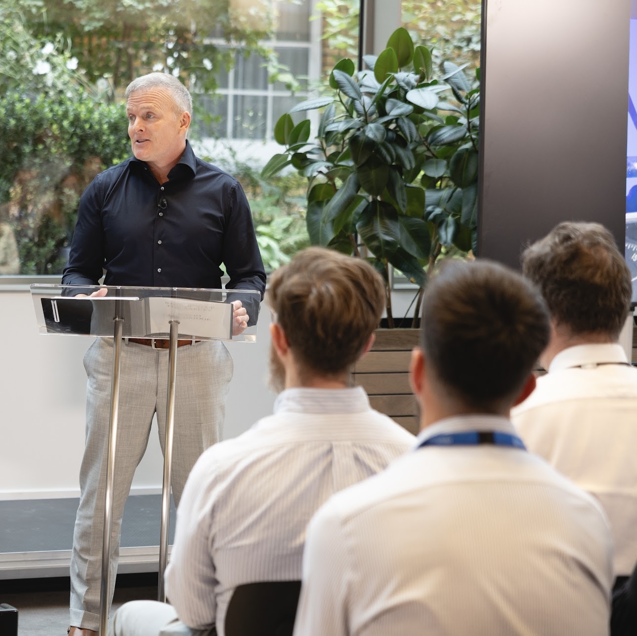 David Lochridge speaking at a podium to a corporate audience